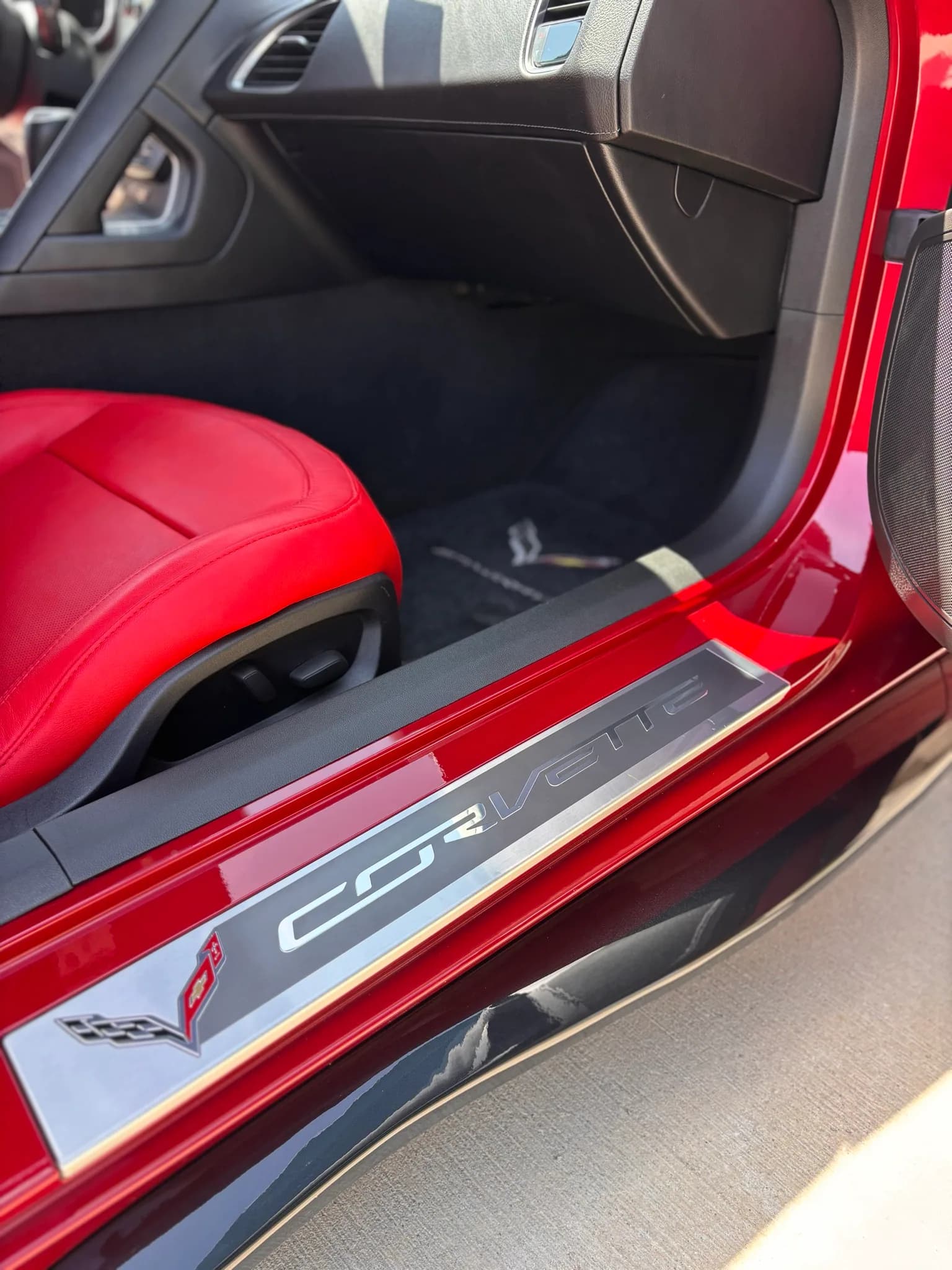 Polished Corvette door sill plate above a clean carpeted floor.