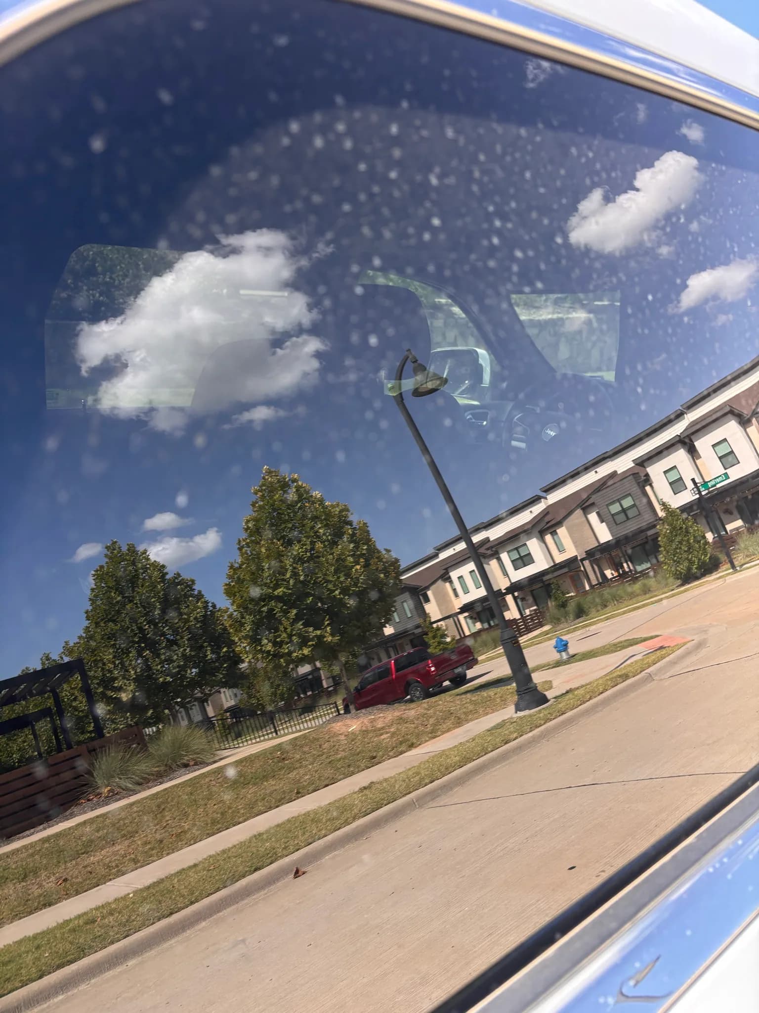 Streak-free side window glass on a Jeep Grand Cherokee reflecting the sky.