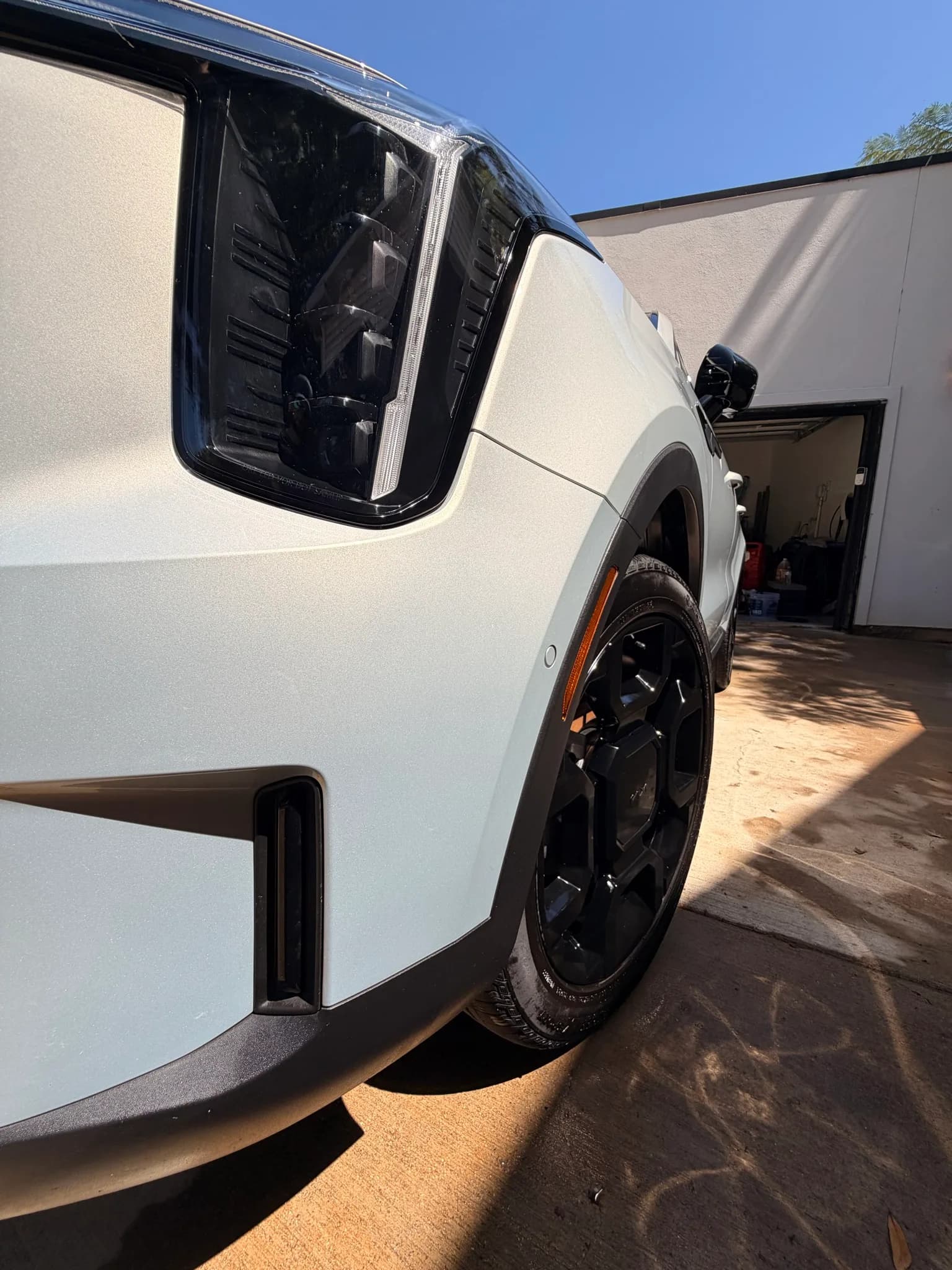 Clean Kia Sorento headlight and glossy front fender close-up.