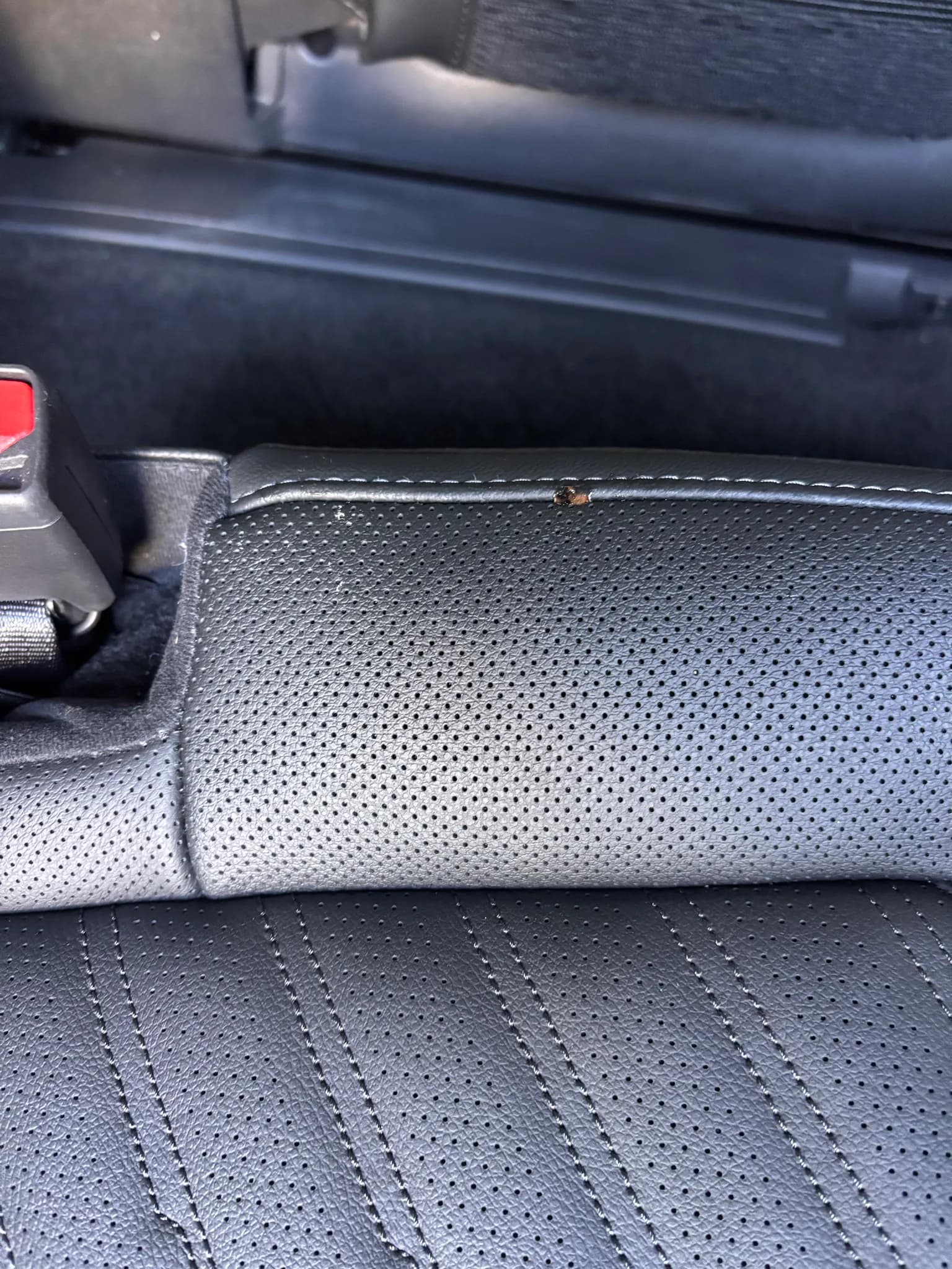 Close-up of perforated leather seat upholstery and stitching in a Kia Sorento.