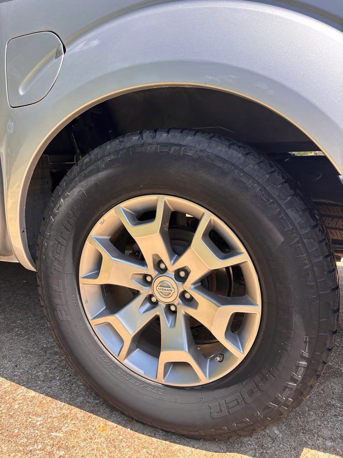 Clean Nissan Frontier wheel, wheel well, and dressed all-terrain tire after detailing.