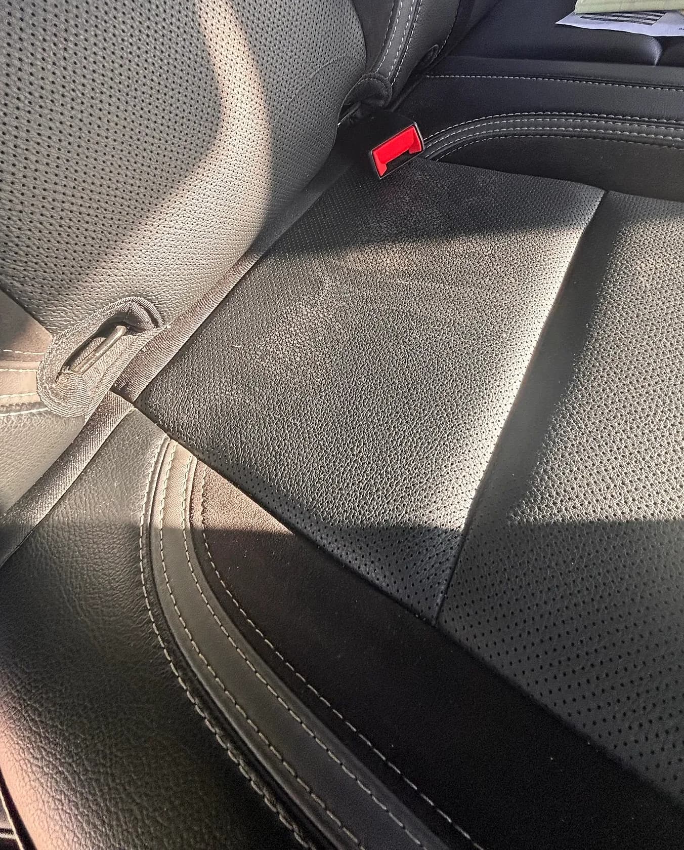 Close-up of perforated leather seat stitching after conditioning.