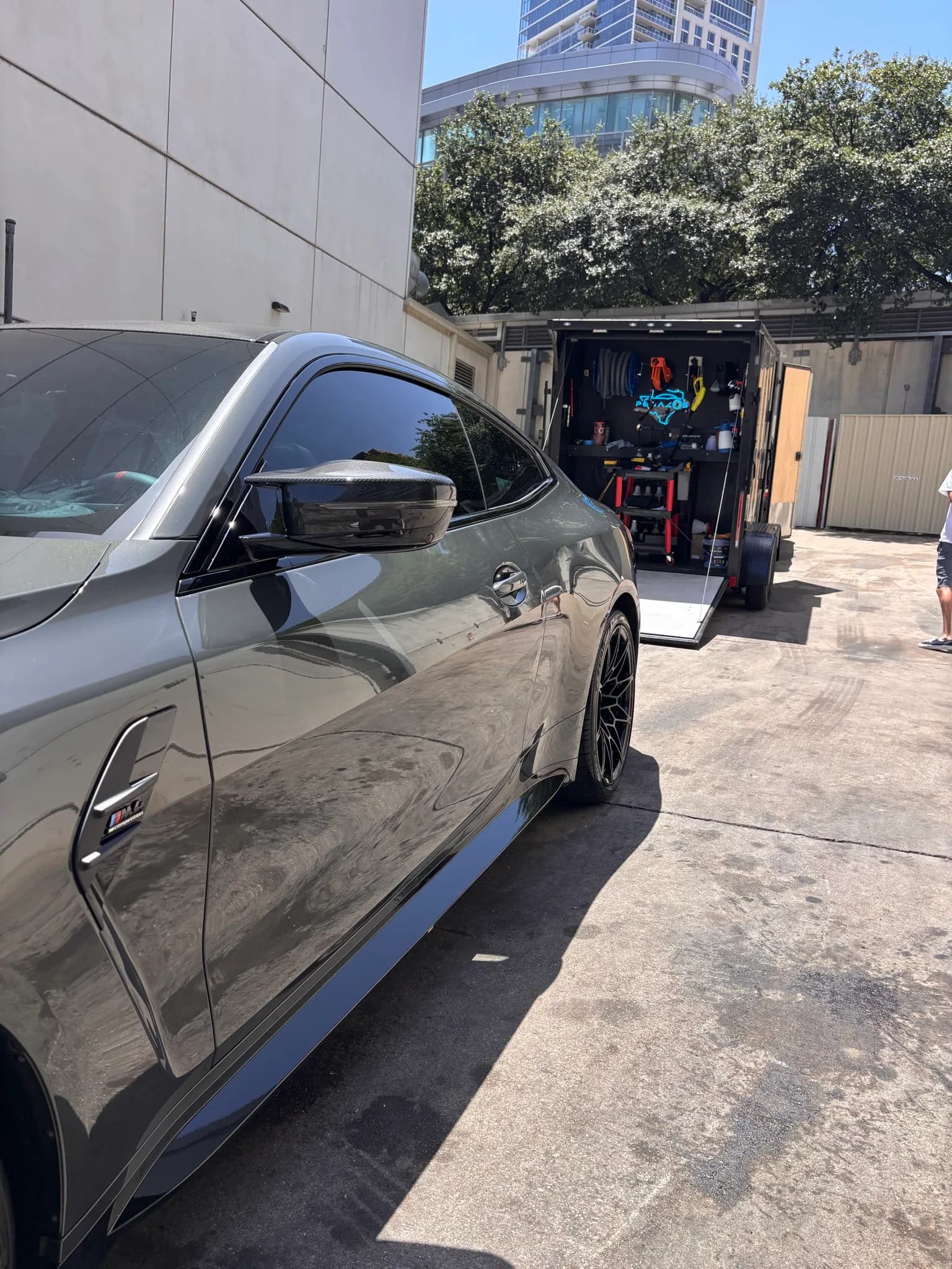 Side profile of a green BMW M4 with freshly cleaned paint and wheels.