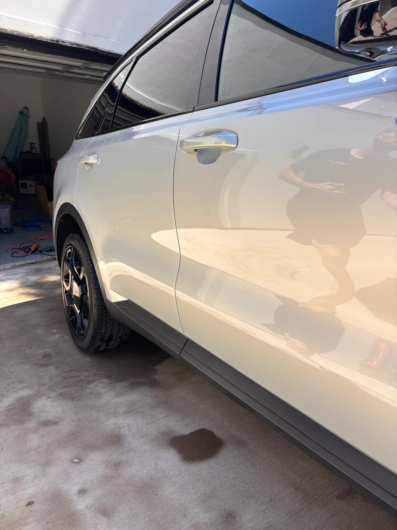 Driver-side doors of a white Kia Sorento showing a deep, reflective paint finish.