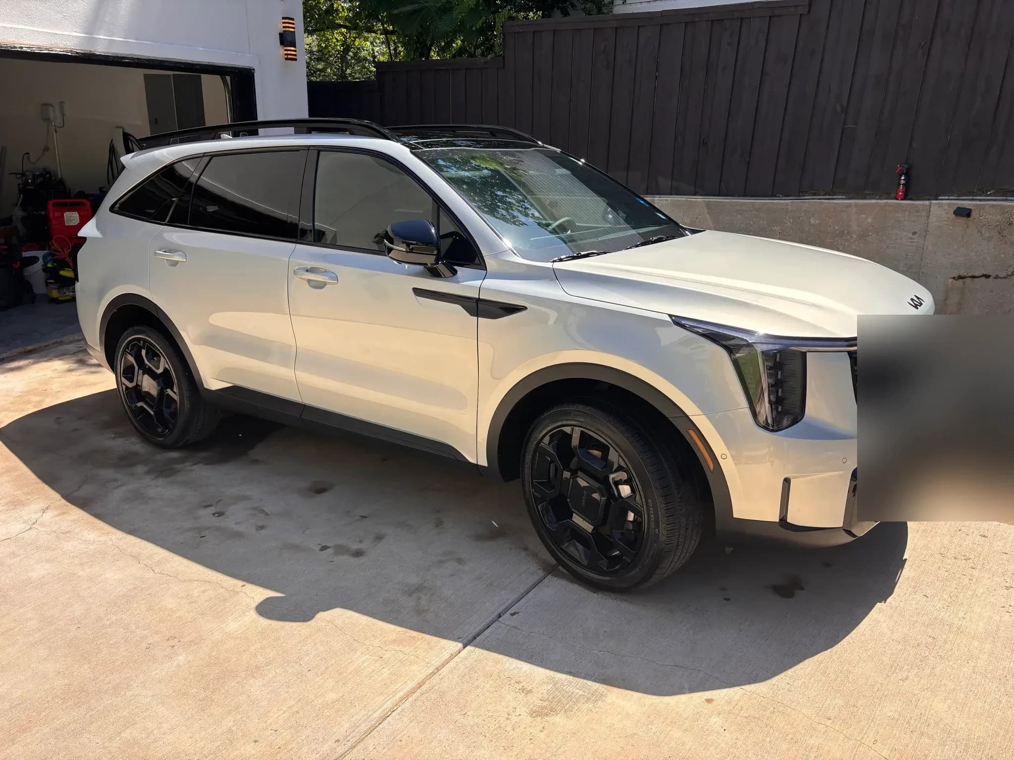 Freshly detailed white Kia Sorento parked on a driveway, shown from the front three-quarter angle.