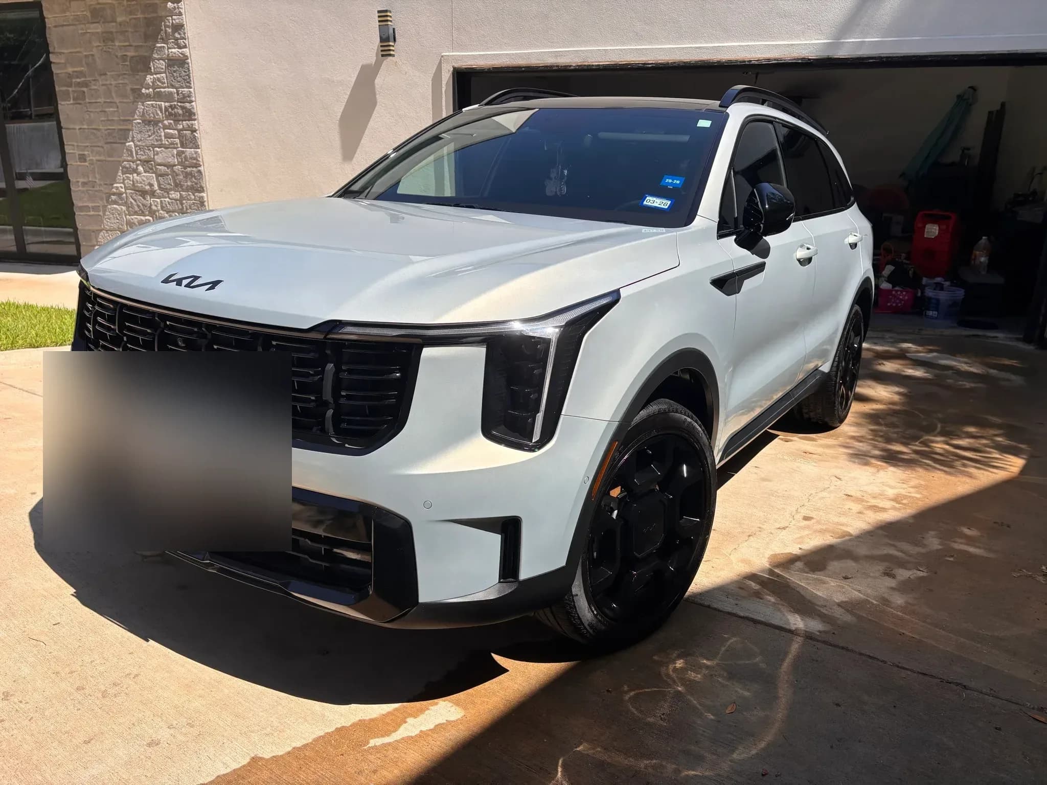 White Kia Sorento X-Line photographed from the front corner on a driveway after detailing.