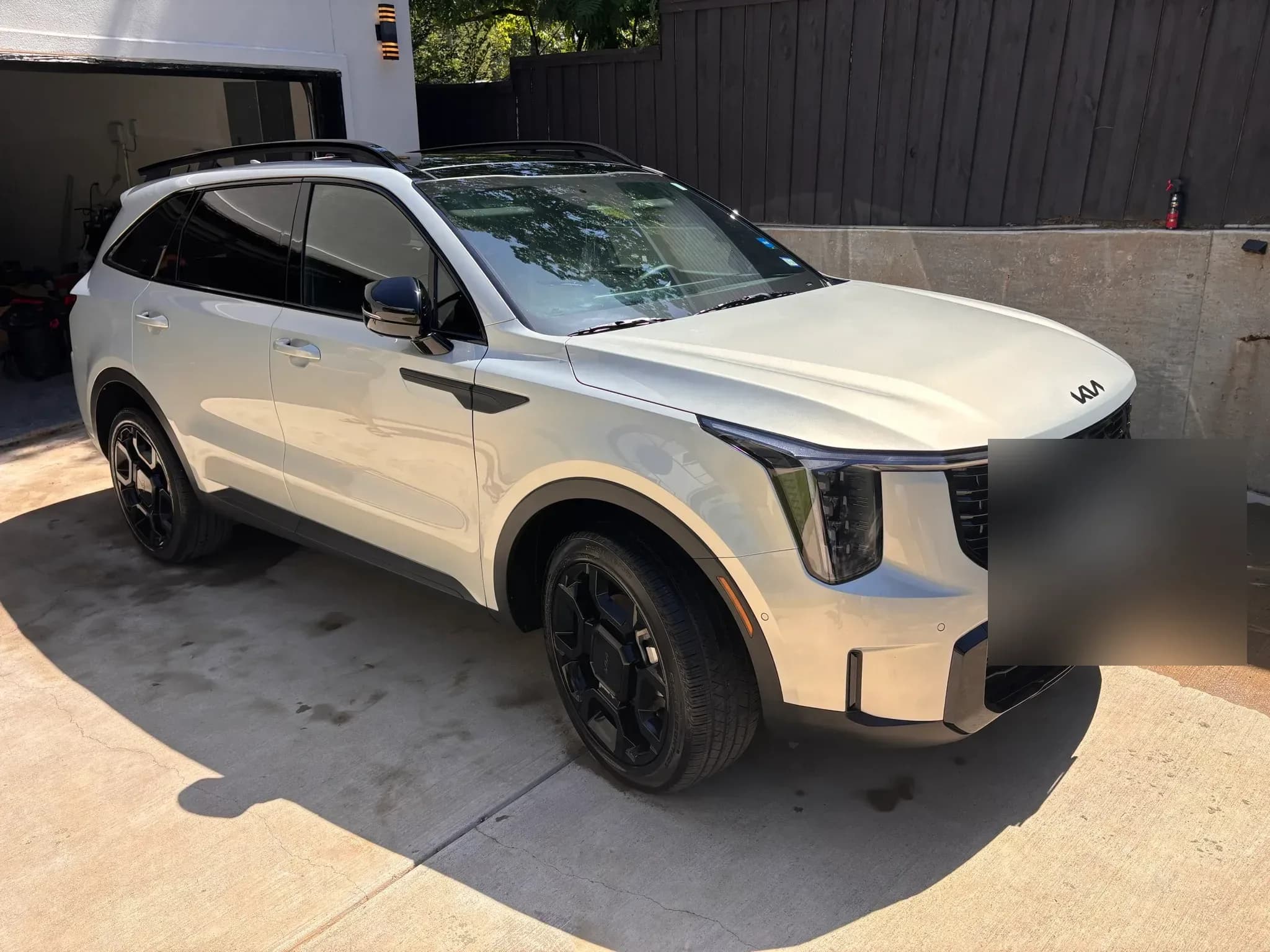 White Kia Sorento with clean paint, glass, wheels, and tires after detailing.