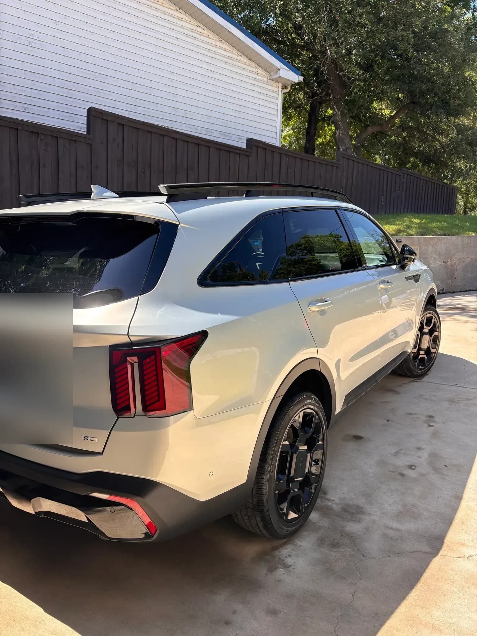 Rear three-quarter view of a freshly detailed white Kia Sorento.