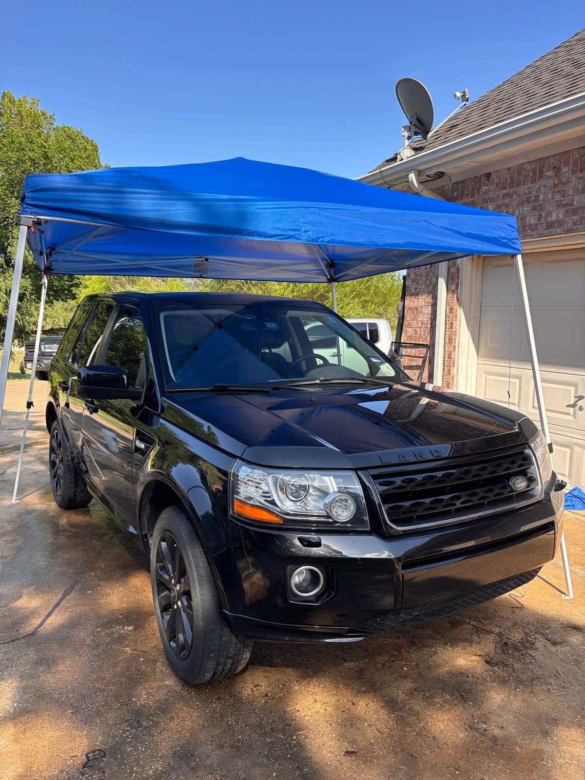 Clean black Land Rover LR2 with deeply reflective paint after detailing.