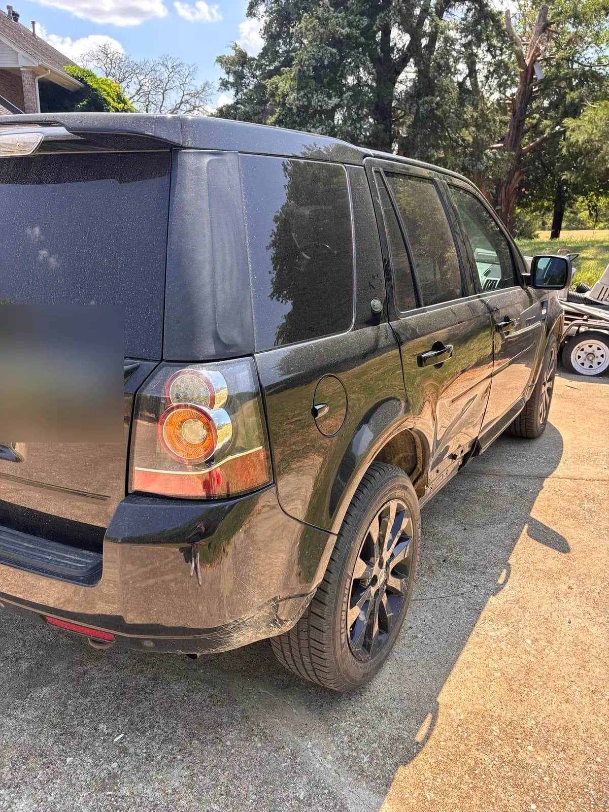 Dust-covered black Land Rover LR2 rear quarter before detailing.