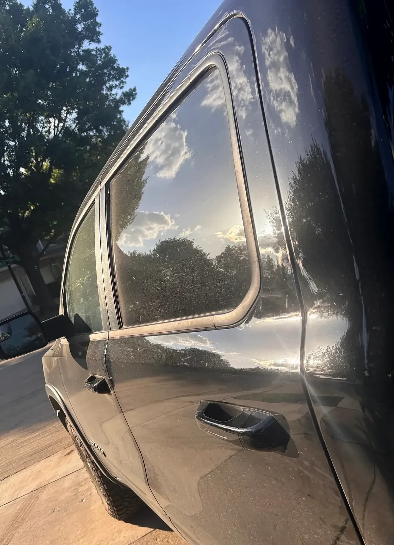 Rear quarter and bed rail of a black Ram 1500.