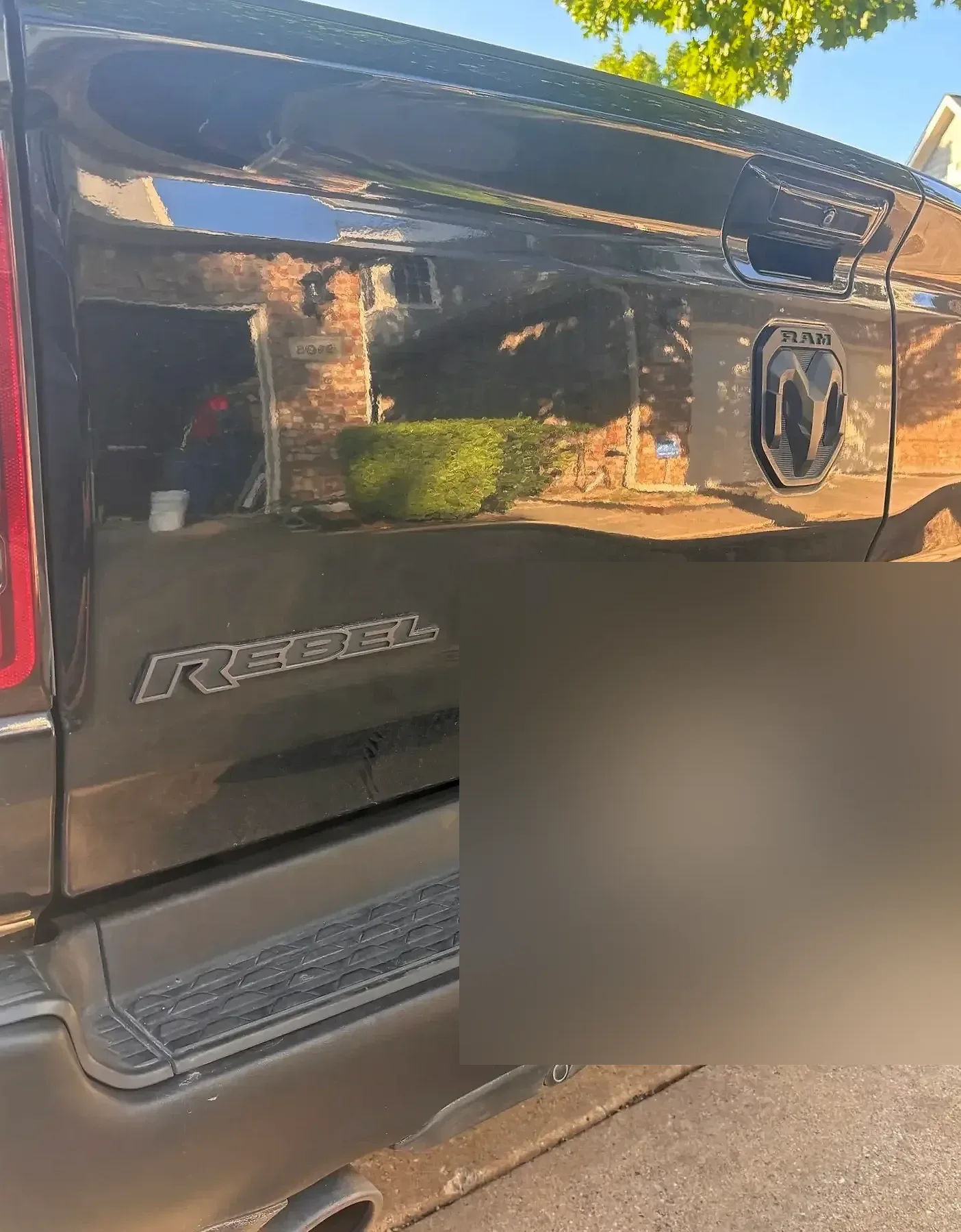 Glossy rear quarter of a black Ram with the RAM emblem.