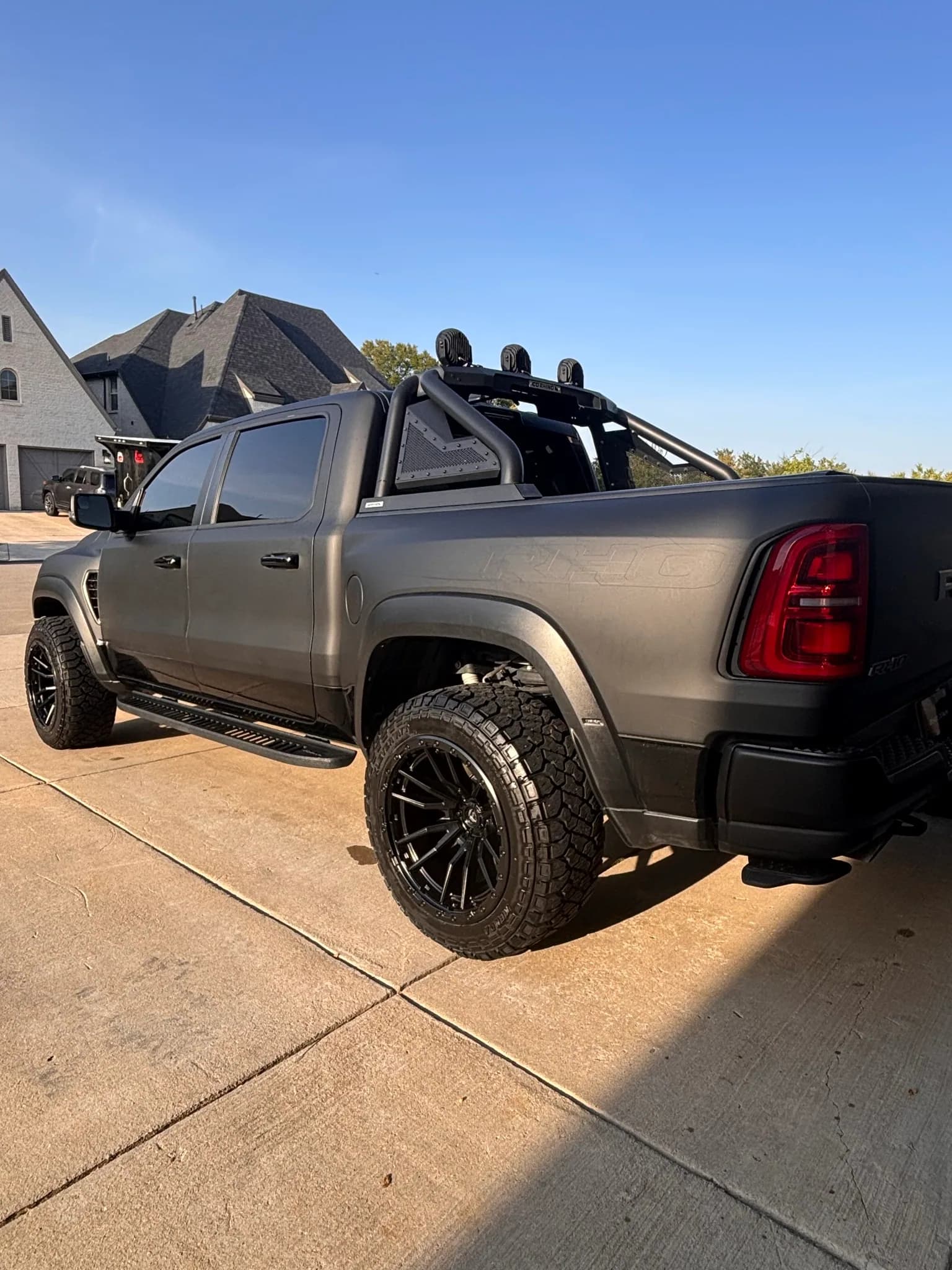 Side profile of a matte grey Ram 1500 TRX showing the bed and wheels.