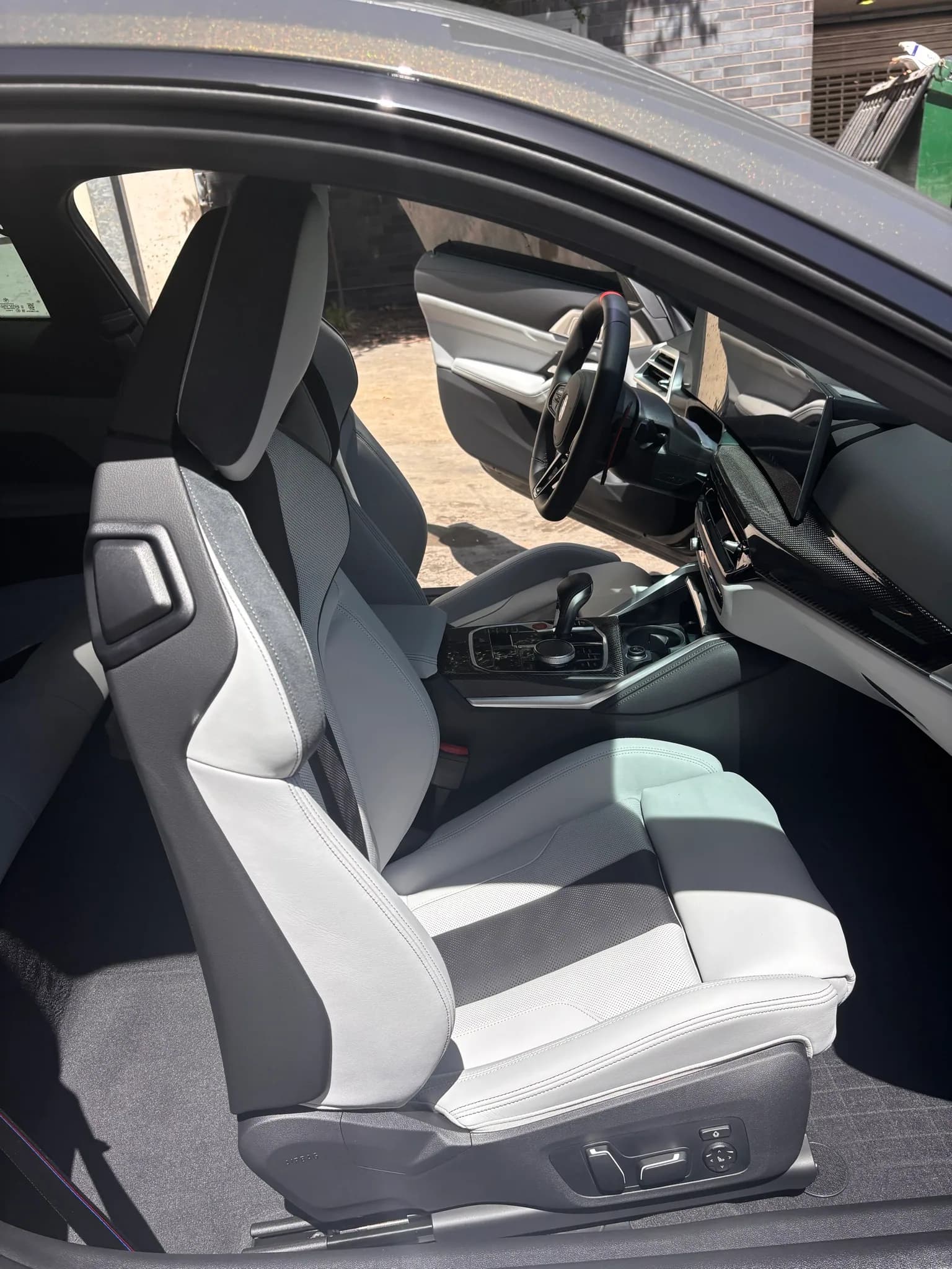 White leather bucket seat and cabin inside a BMW M4.