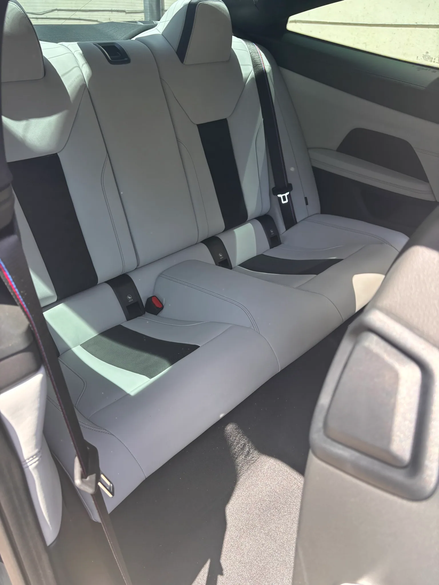 White leather rear seats inside a BMW M4 after an interior detail.