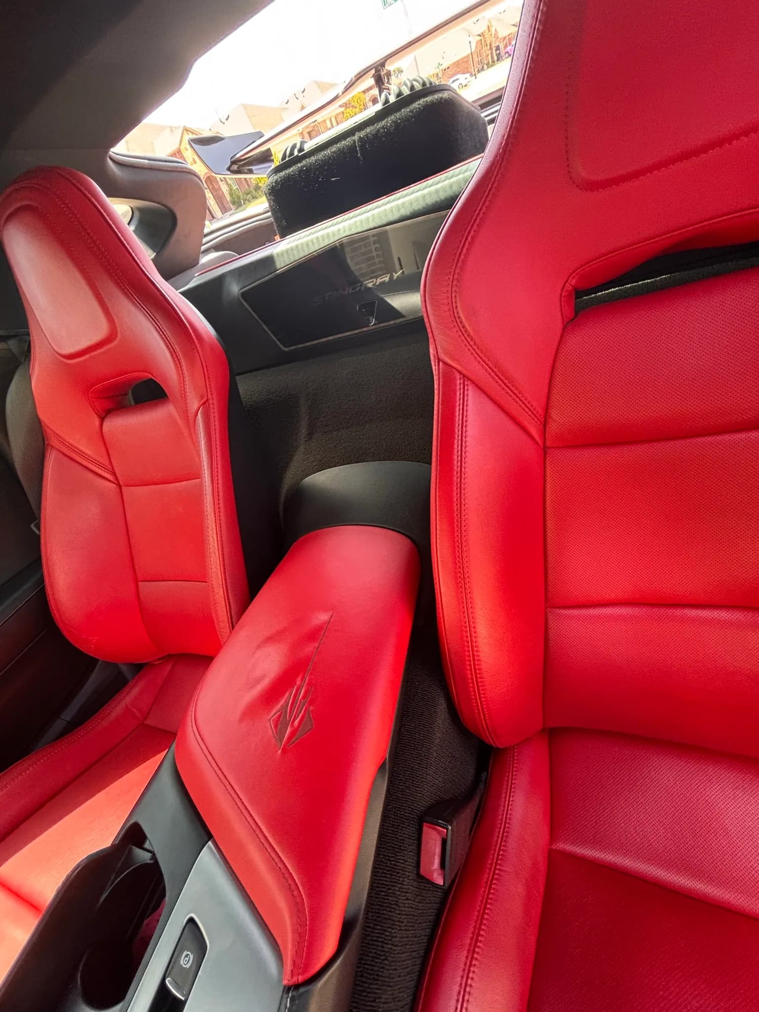 Overhead view of both red leather seats and the console inside a Corvette.