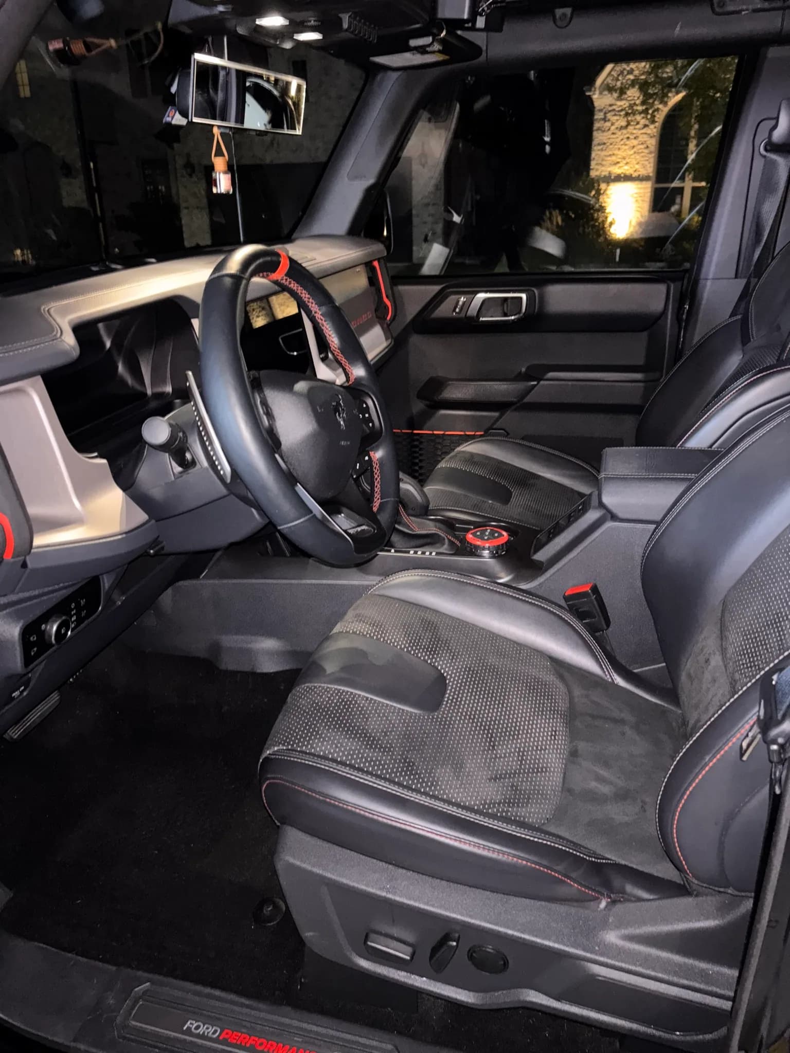Driver seat, steering wheel and console inside a Ford Bronco Raptor after cleaning.
