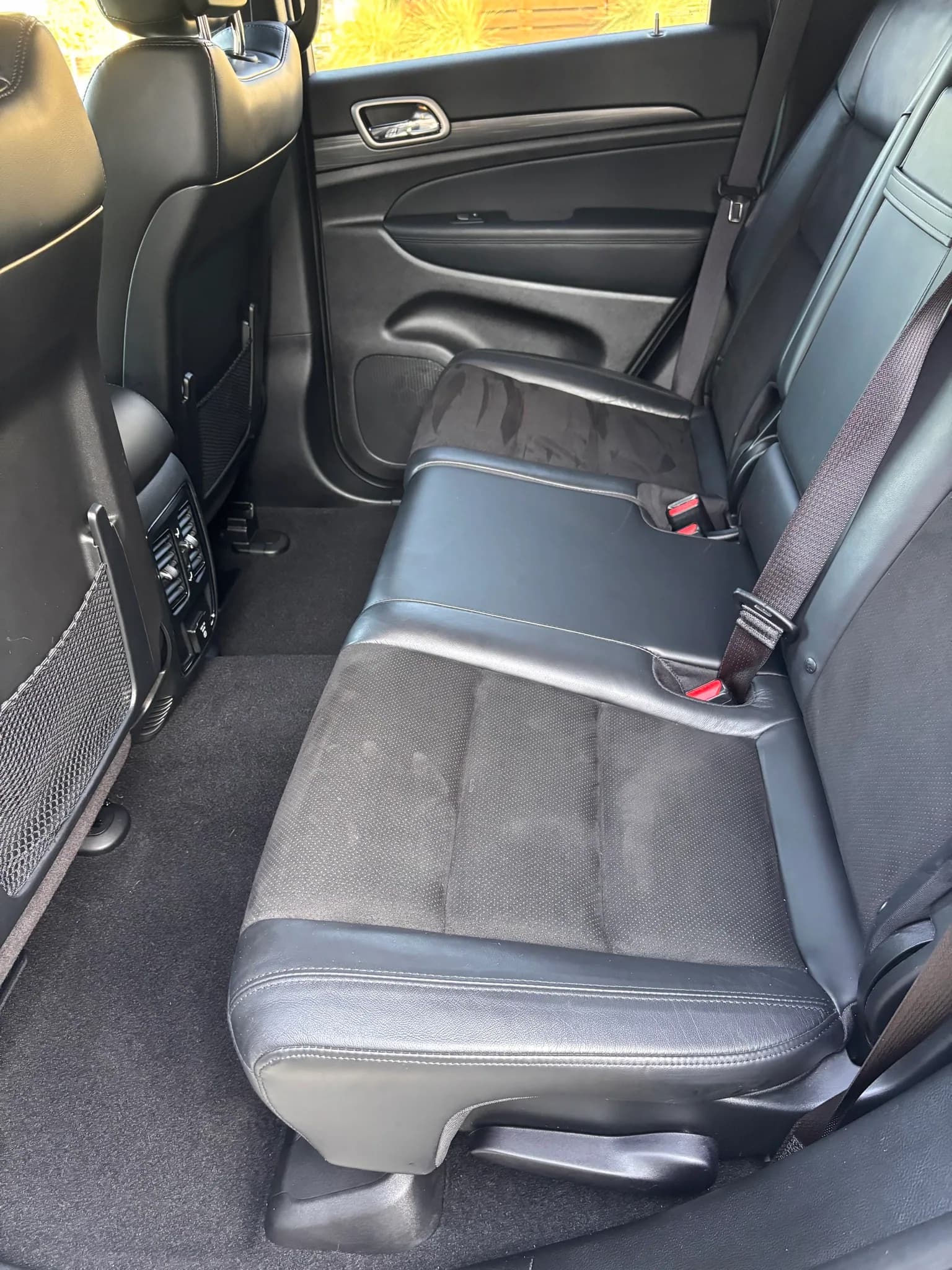 Rear bench seat and door panel inside a Jeep Grand Cherokee.