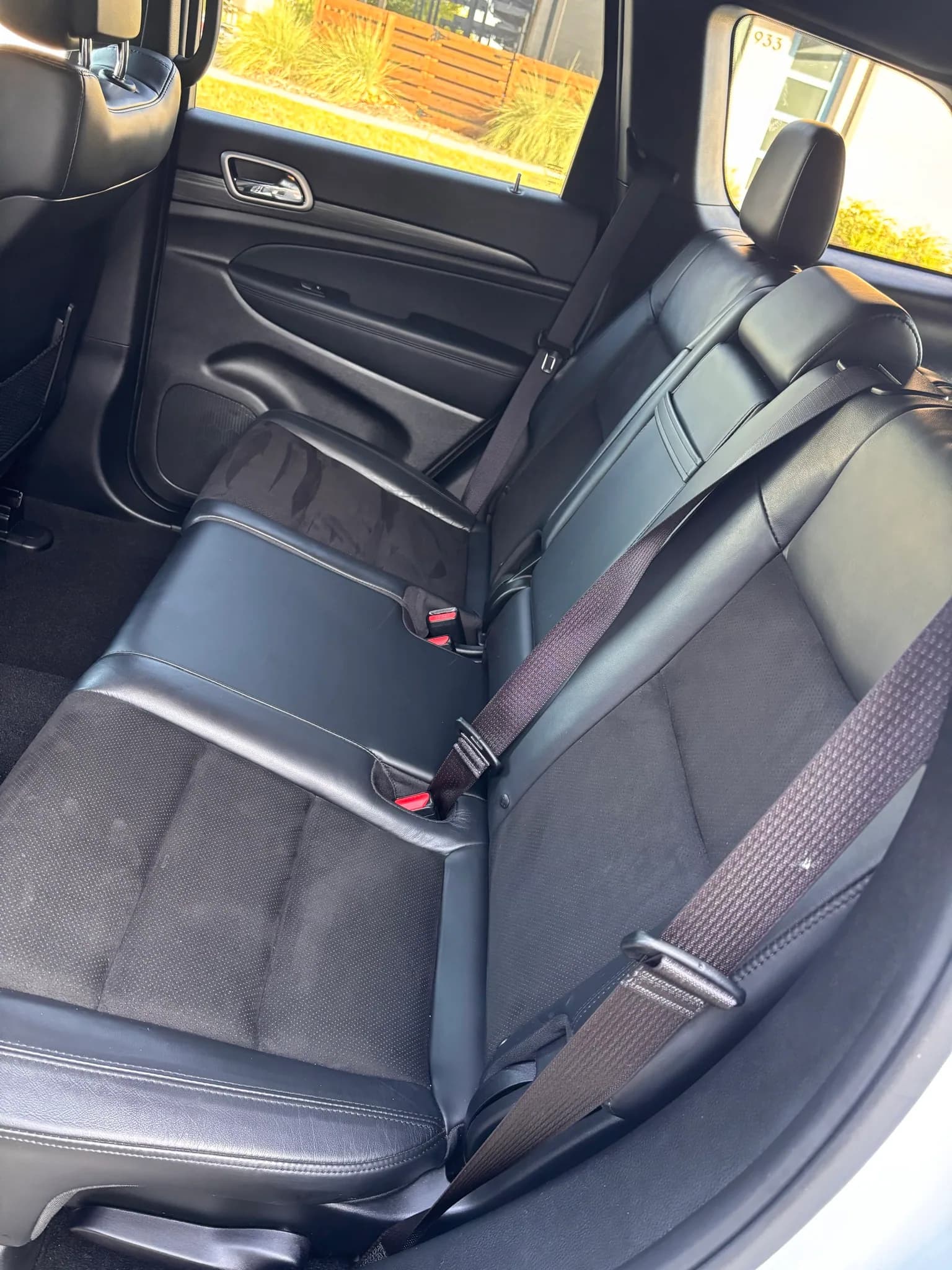 Cleaned rear leather bench seats inside a white Jeep Grand Cherokee.