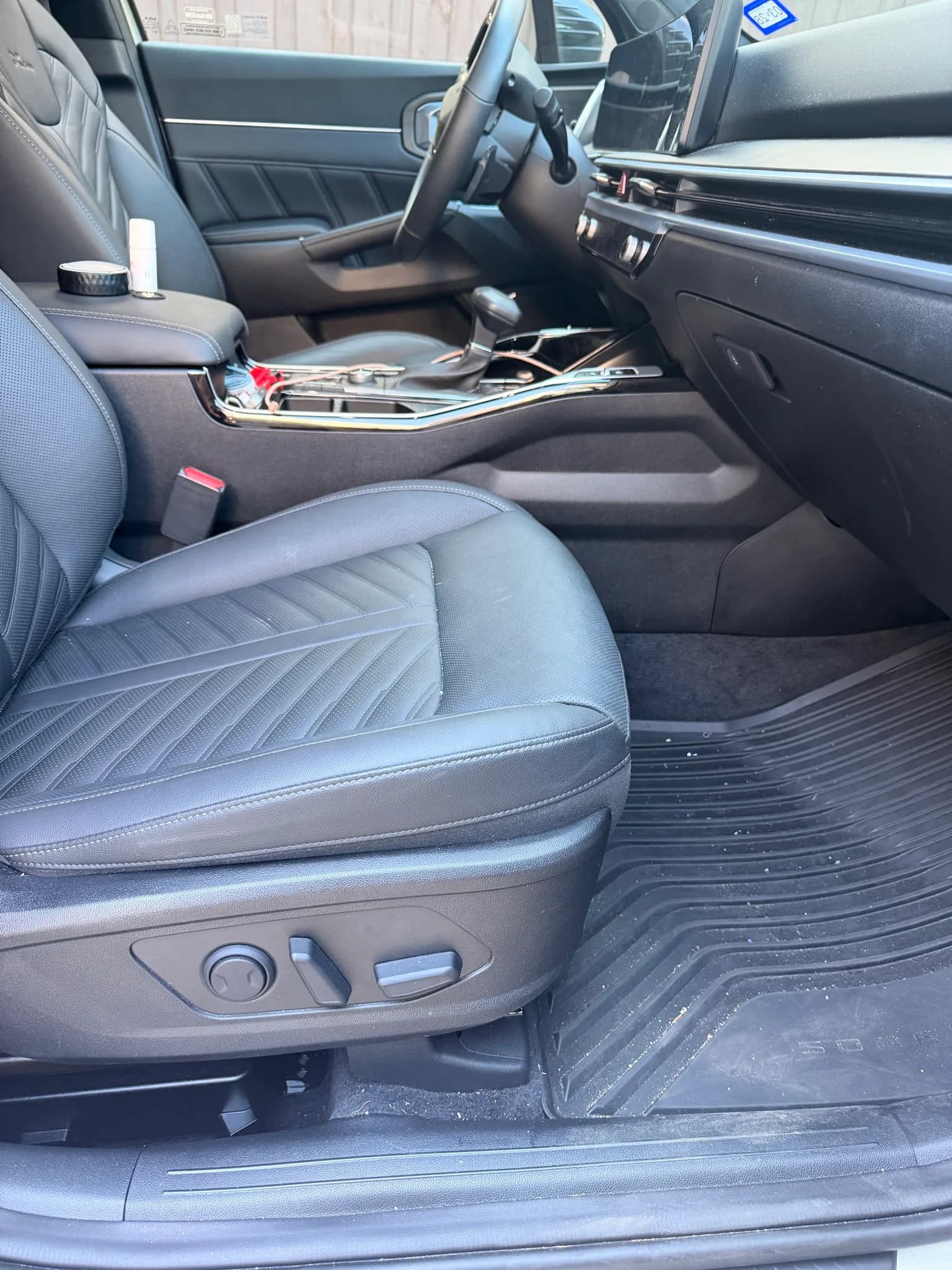 Front passenger seat and console of a Kia Sorento with black leather upholstery.