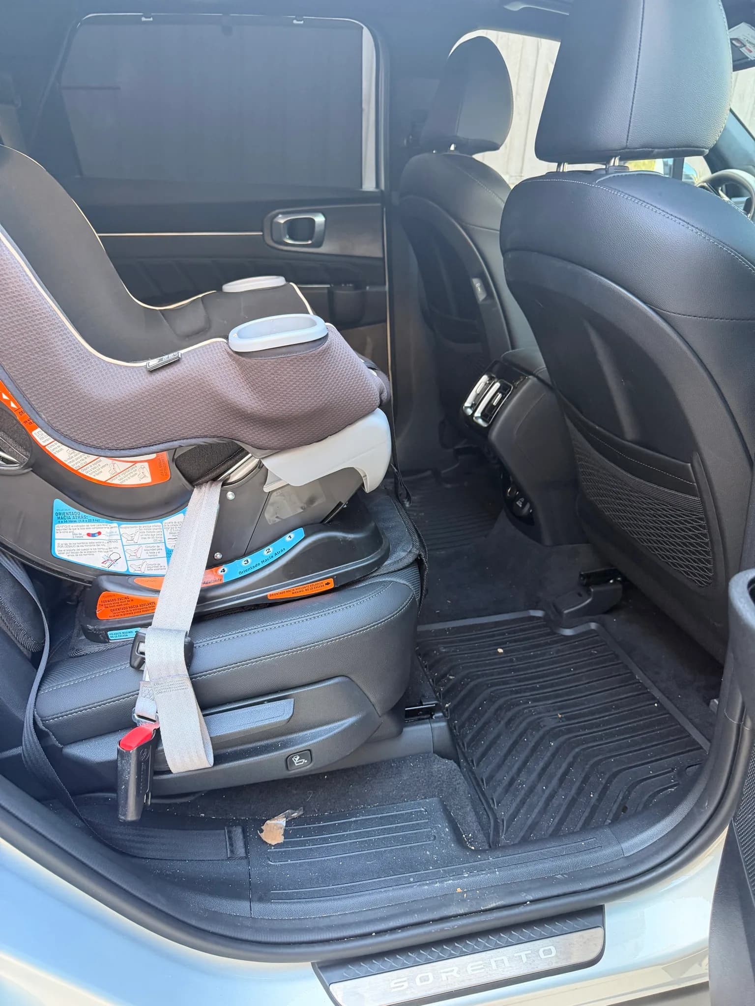 Rear seating area of a Kia Sorento with a child car seat installed.