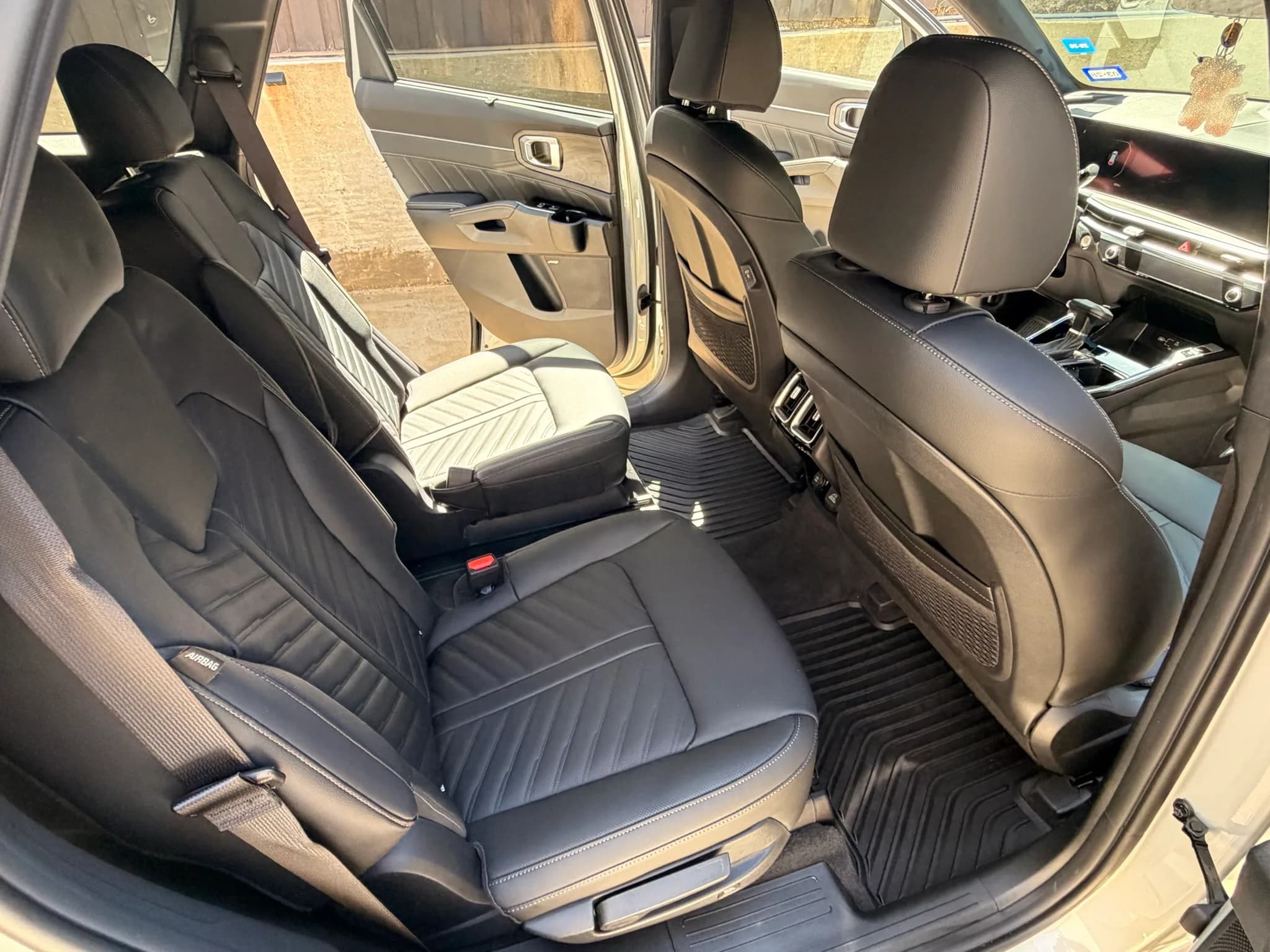 Clean second-row seats, carpet, mats, and trim inside a Kia Sorento.