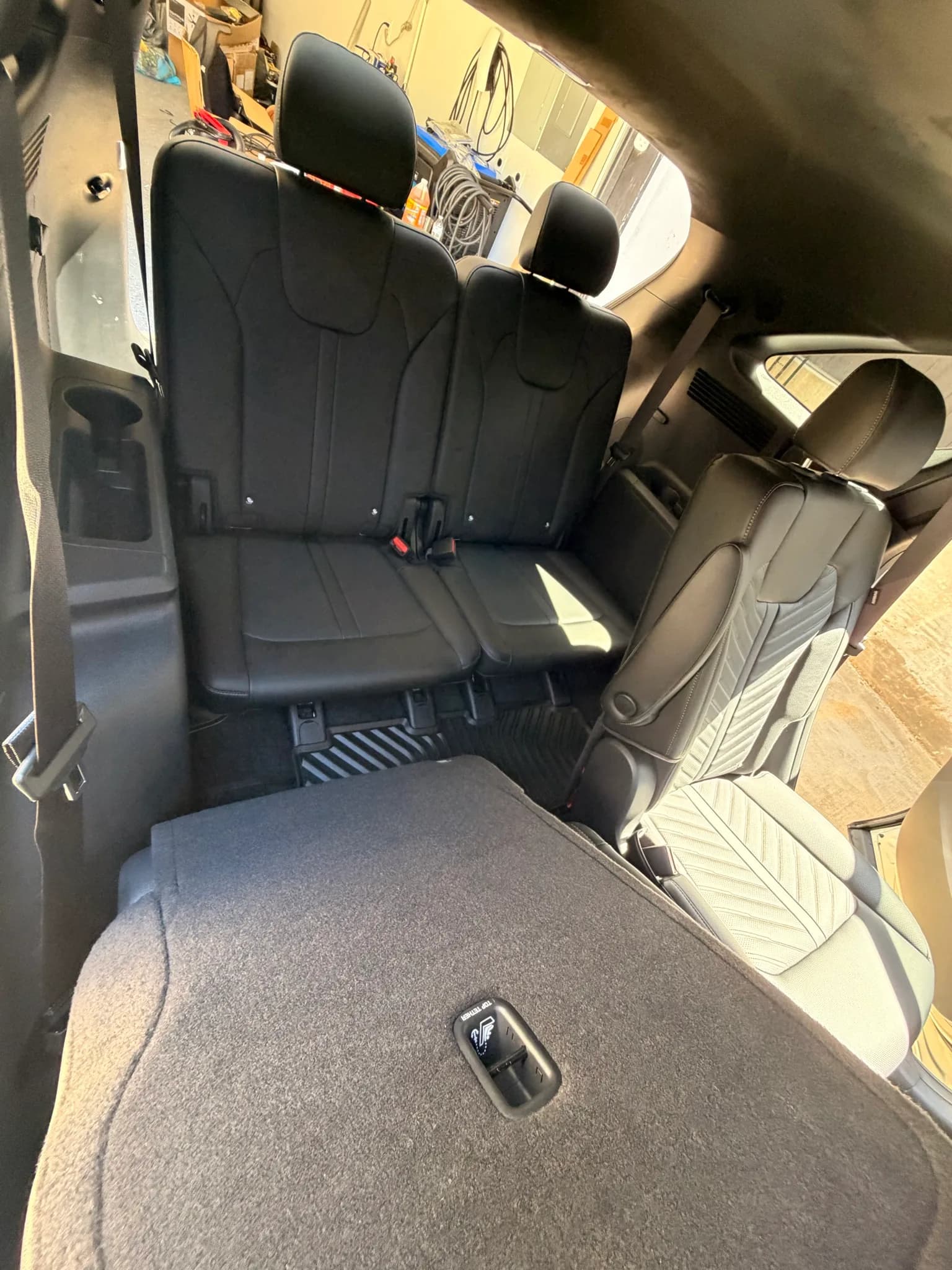 Third-row seats and folded second row of a Kia Sorento after a full interior clean.
