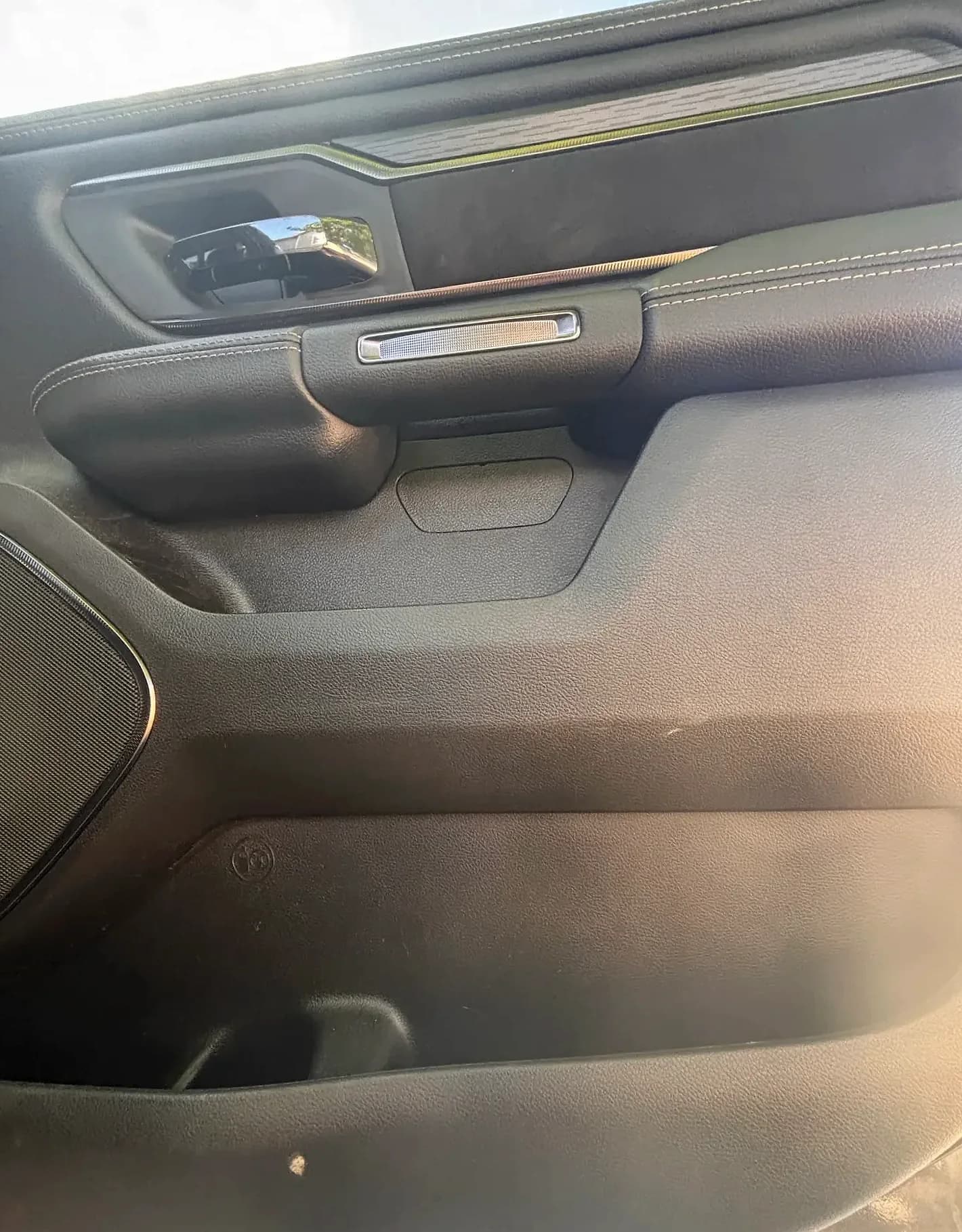Front door panel with speaker, handle and armrest, detailed.