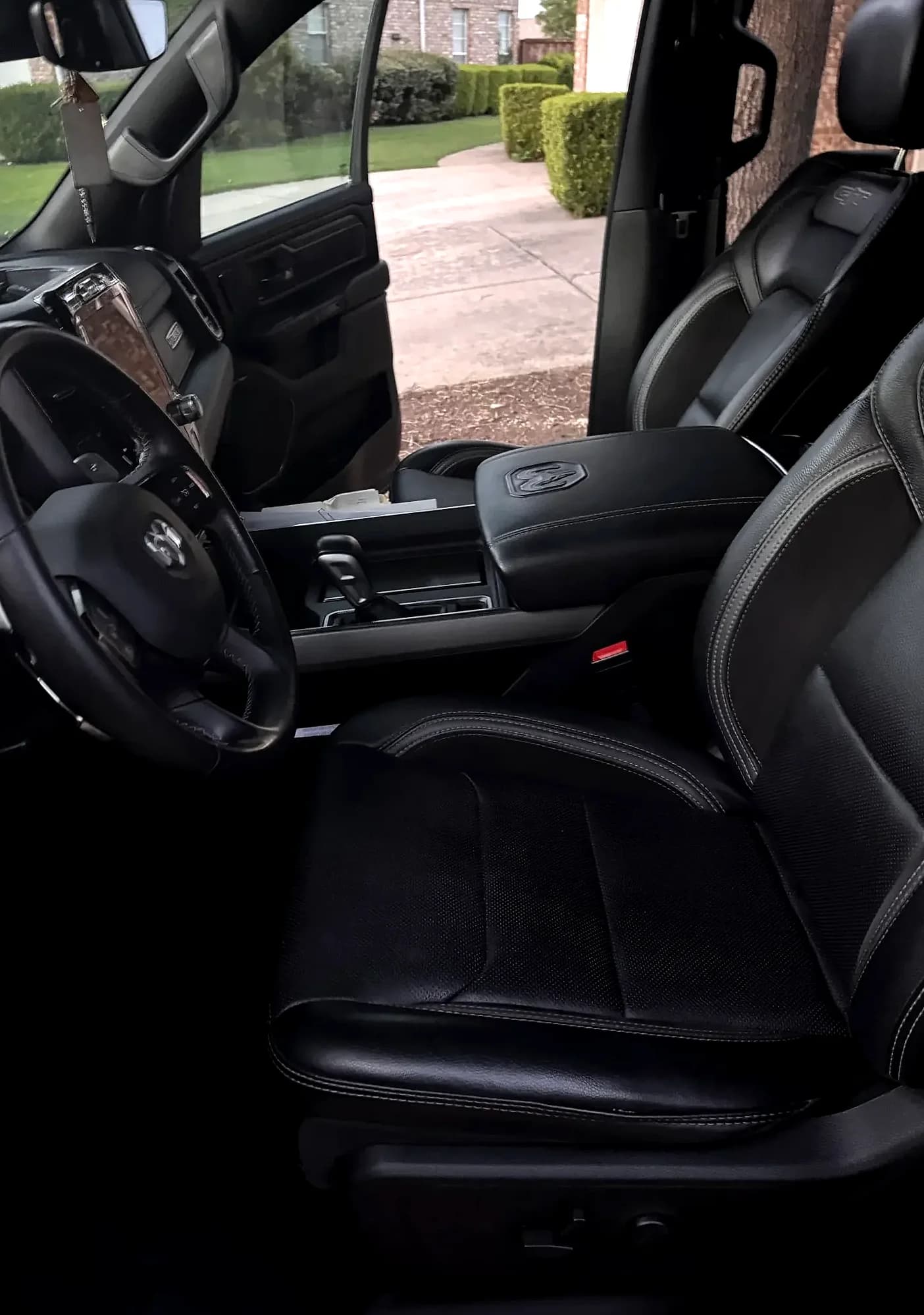Front cabin, seats and dashboard of a black Ram 1500.