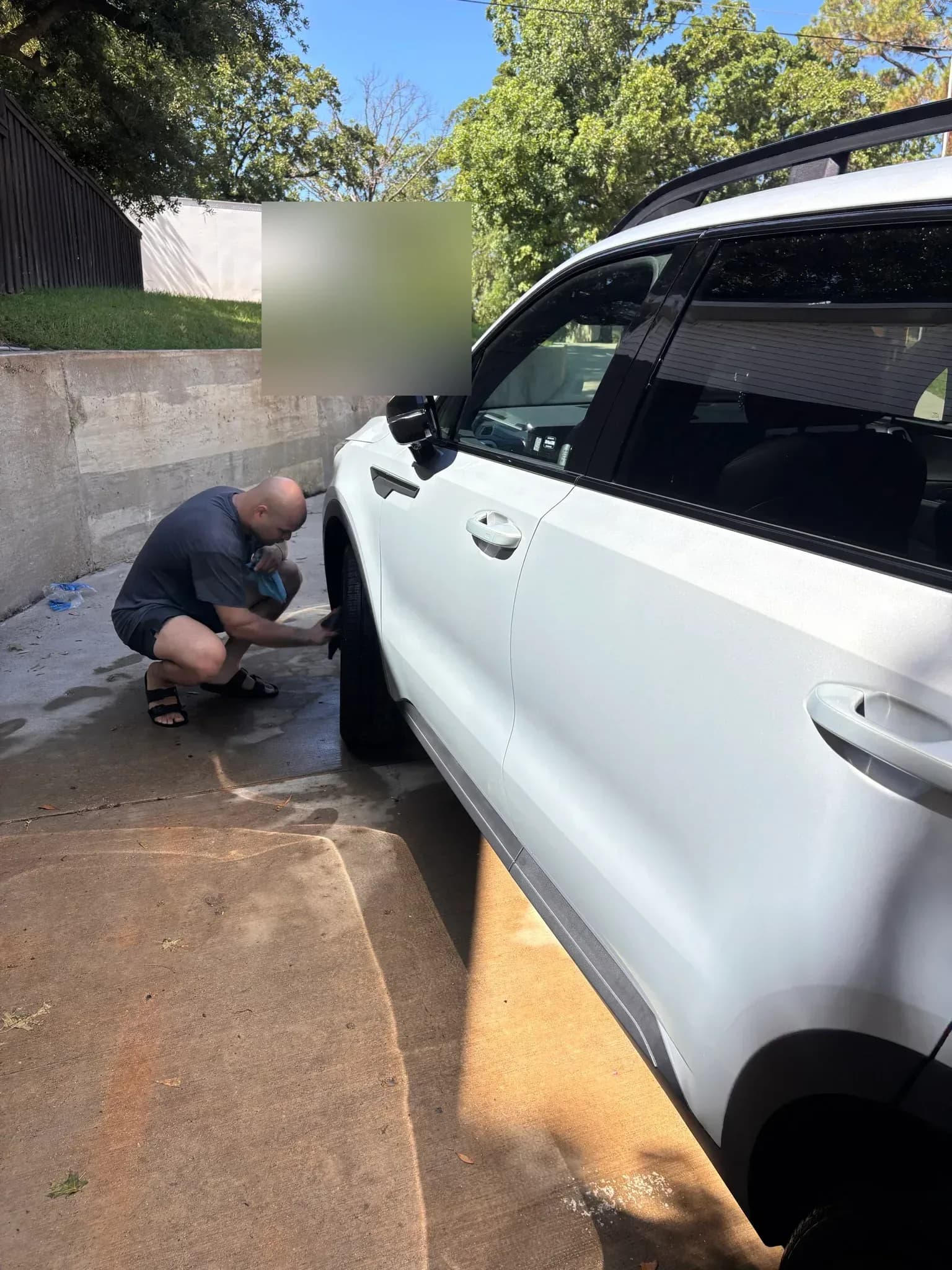 Detailer applying an even tire dressing to a Kia Sorento.