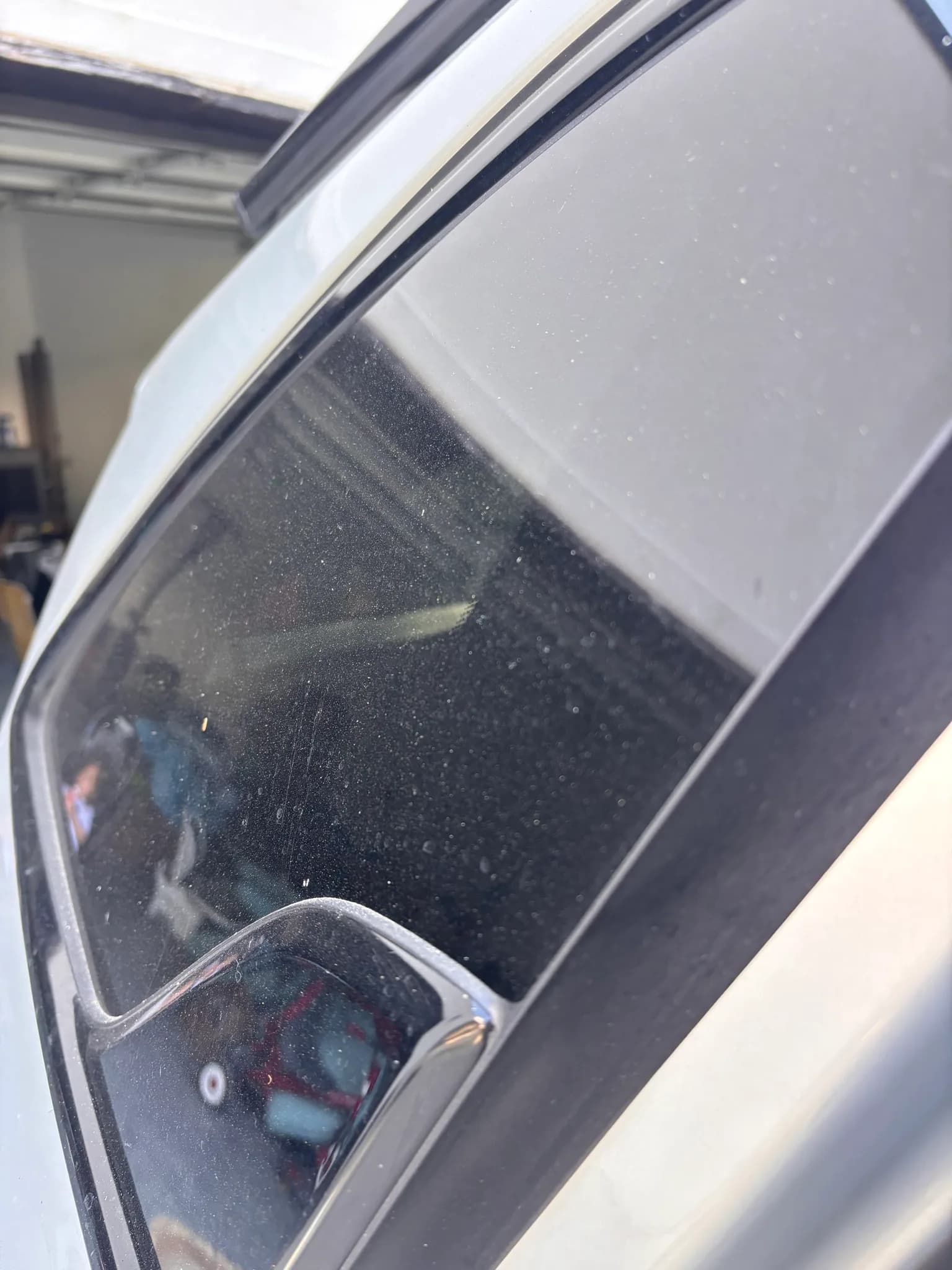 Dust-covered window glass and pillar trim on a Kia Sorento before cleaning.