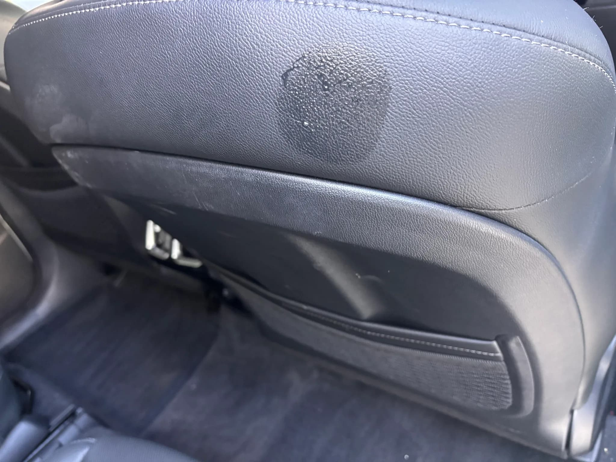 Close-up of a discolored patch on the back of a leather seat in a Kia Sorento.
