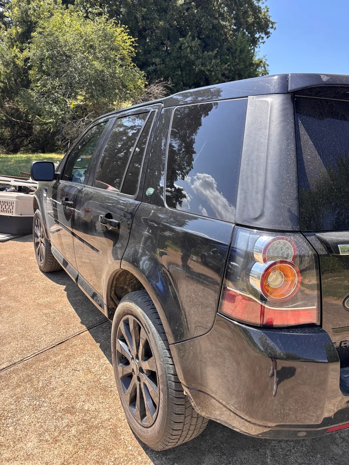 Dust-covered black Land Rover LR2 photographed from the rear quarter before detailing.