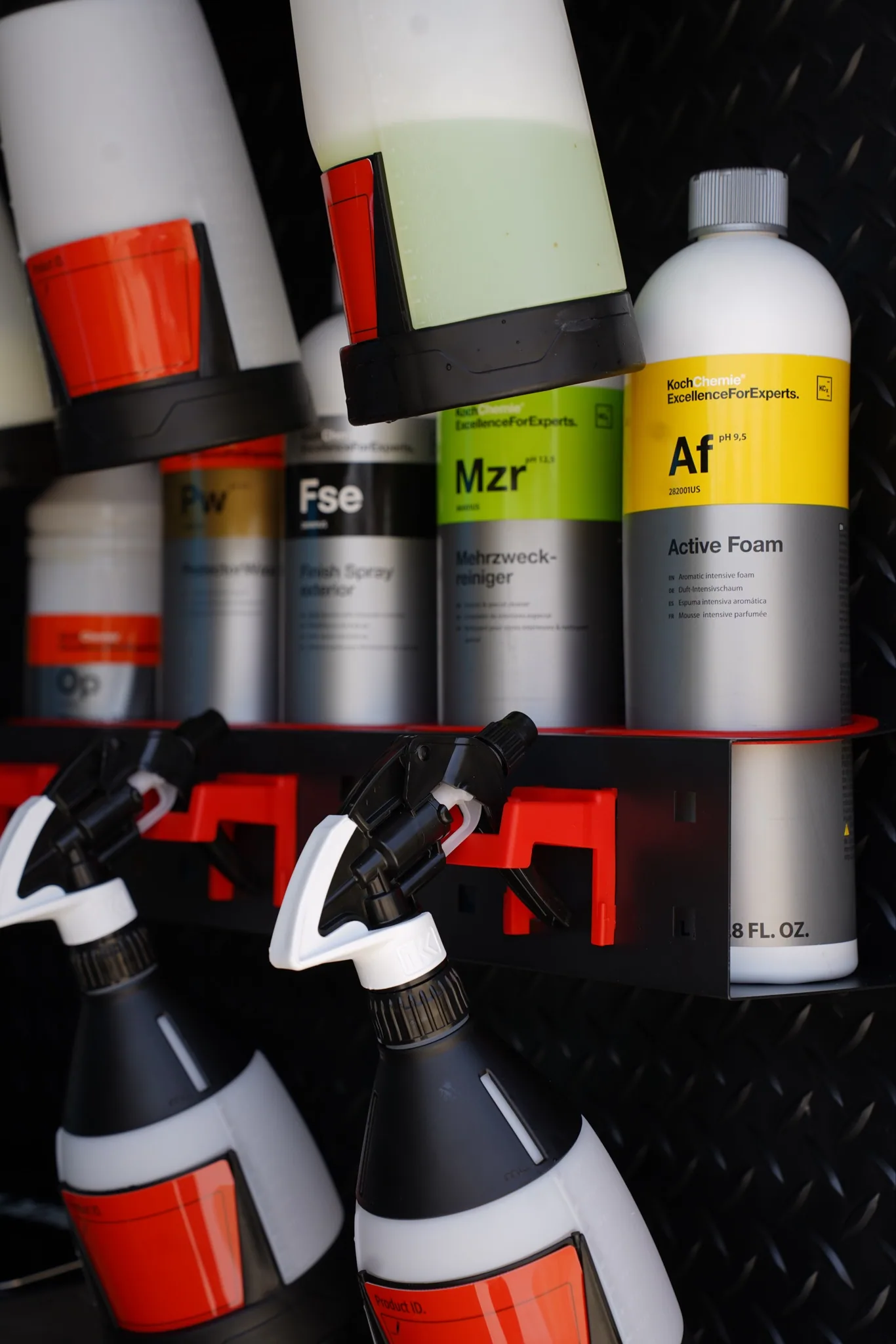 Detailing chemicals and pump sprayers racked on the wall of the mobile trailer.