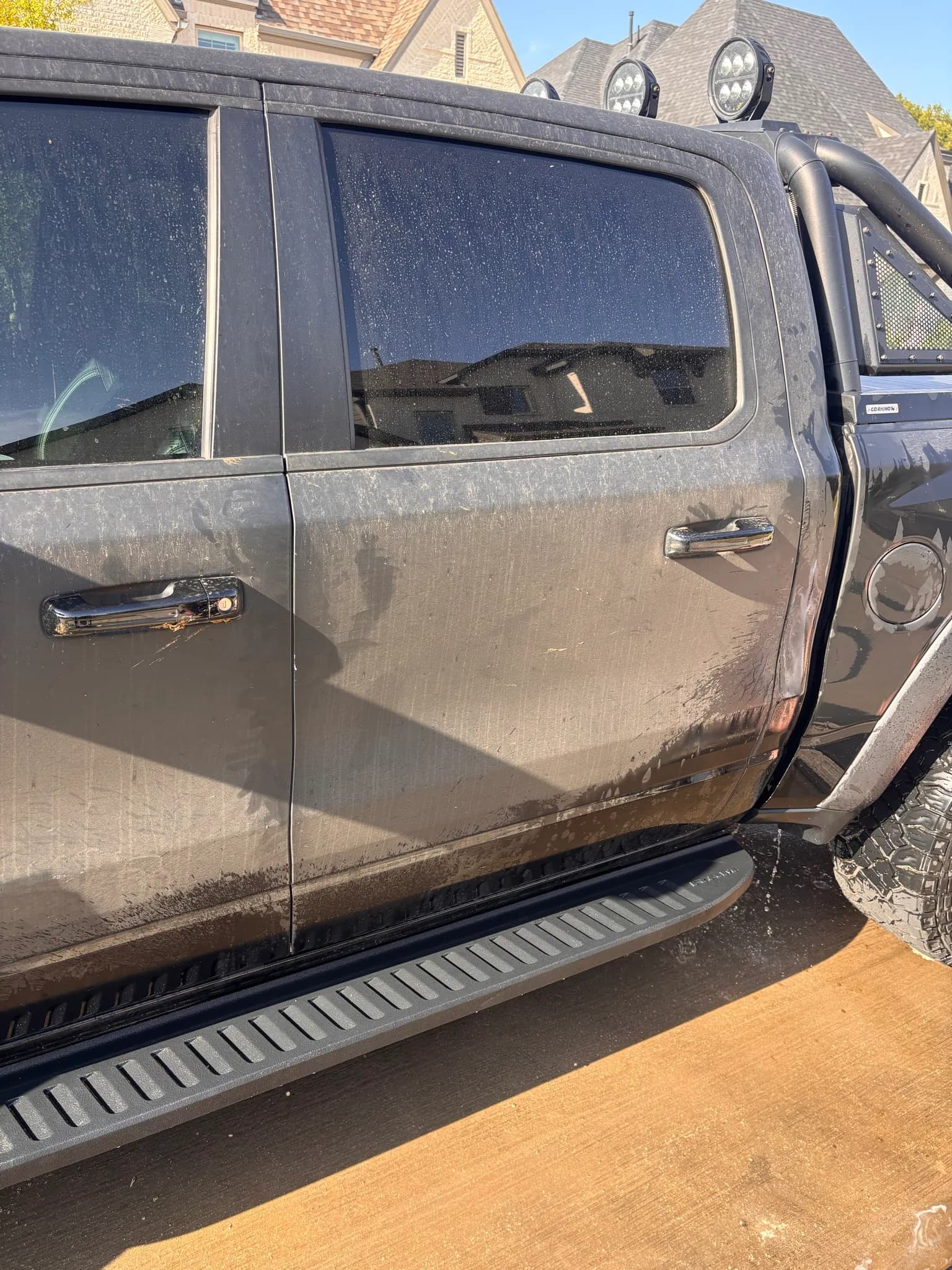 Dust-streaked door, running board and rocker on a Ram 1500 TRX before the wash.