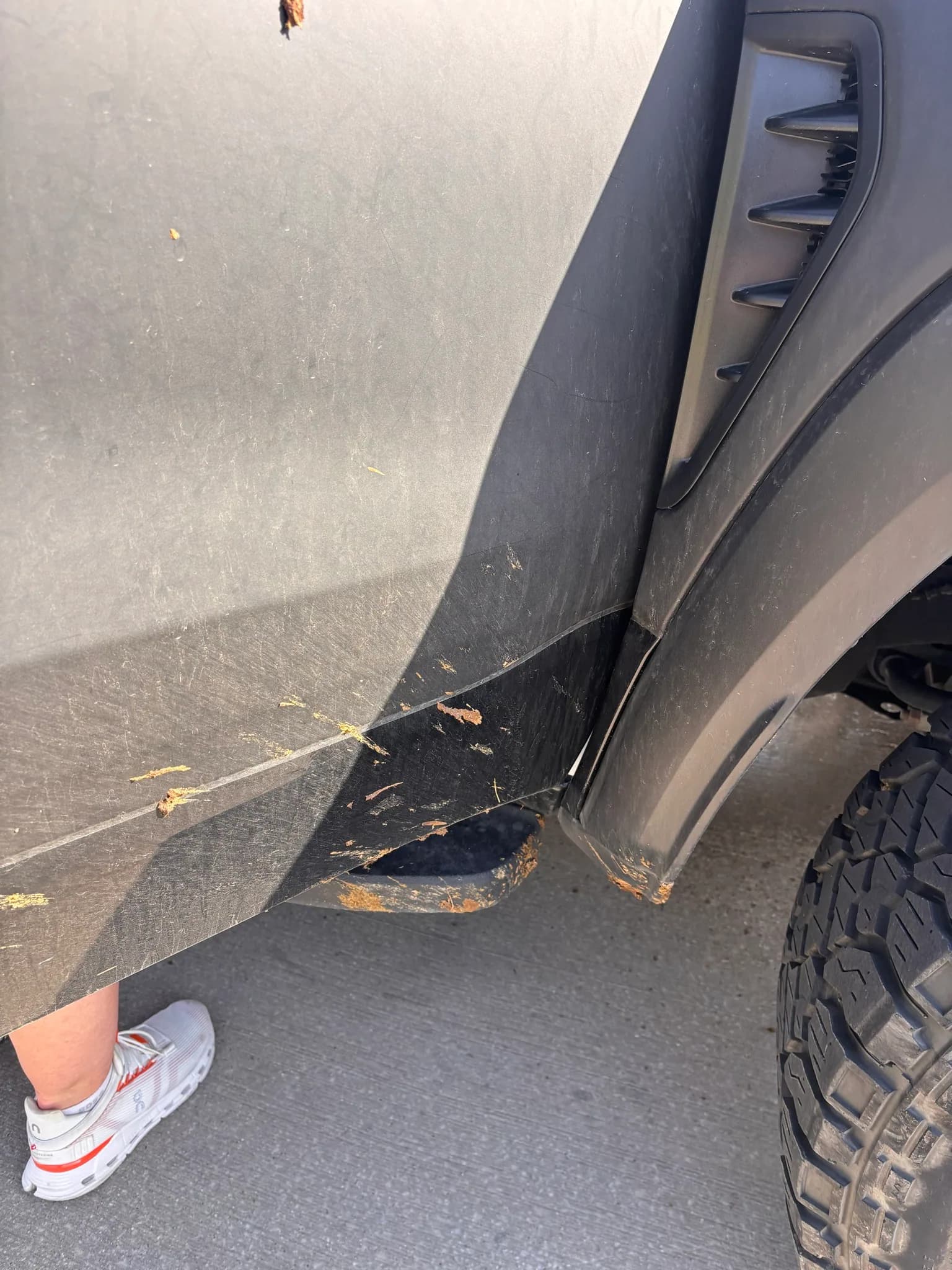 Mud-caked flap and rocker panel on a Ram 1500 TRX before cleaning.