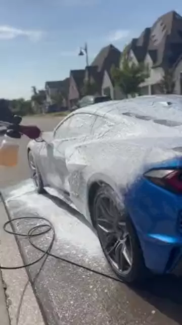 Detailer covering a blue Corvette C8 Z06 in wash foam, alongside footage of a Corvette C7, a C8 Z06 cabin, and a Ram 1500 TRX.